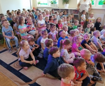 Na zdjęciu znajdują się dzieci z przedszkola. Dzieci oglądają przedstawienie w wykonaniu aktorów z Teatru Ekostudio z Opola.  - powiększ