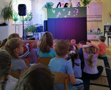 Na zdjęciu znajdują się dzieci z przedszkola. Dzieci oglądają przedstawienie w wykonaniu aktorów z Teatru Ekostudio z Opola.  - powiększ